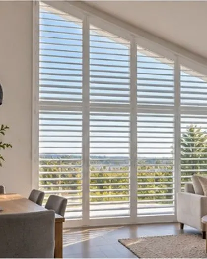 White plantation shutters on a raked ceiling window